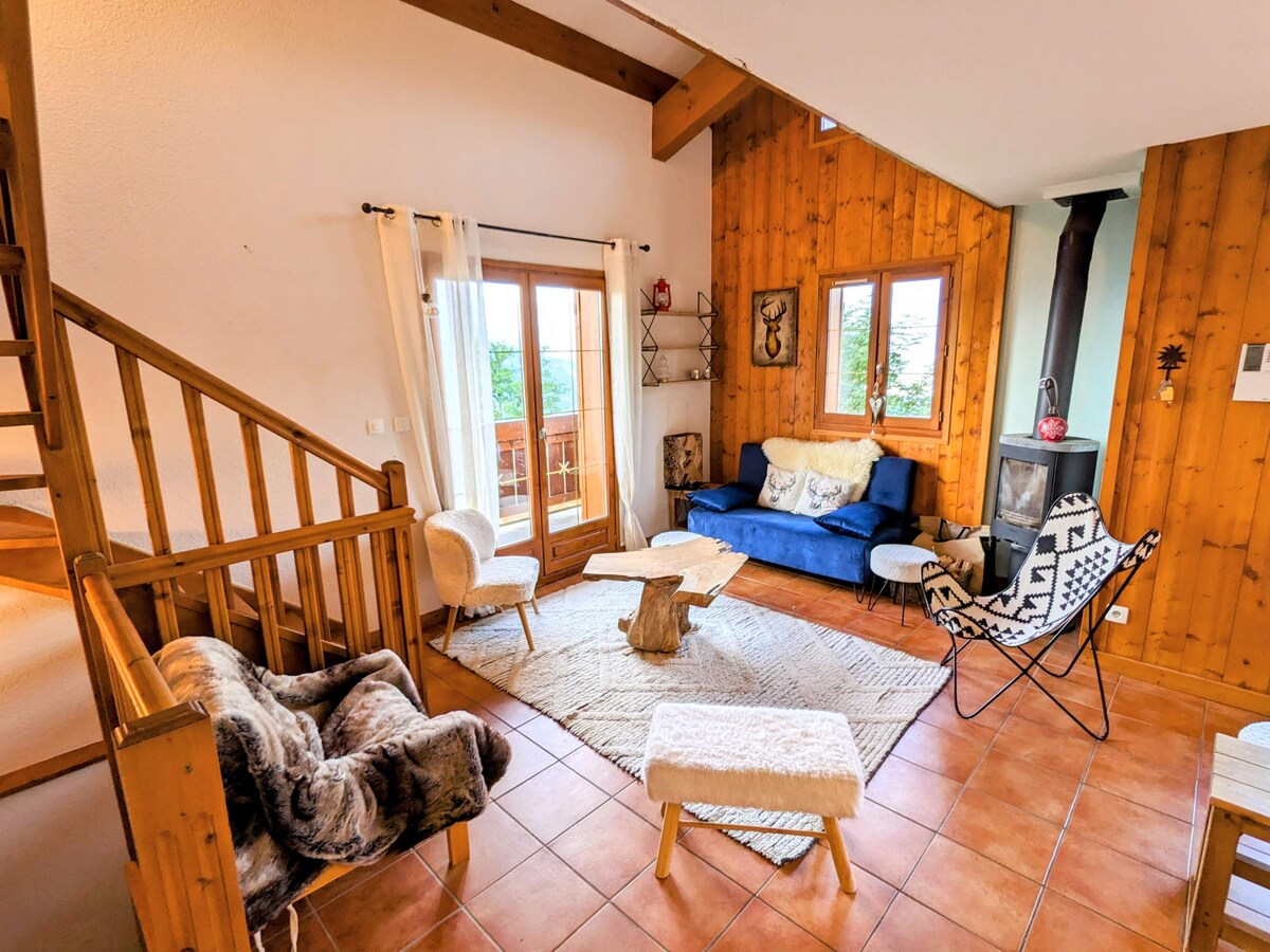 Le salon et ses grandes fenêtres ouvertes sur les montagnes